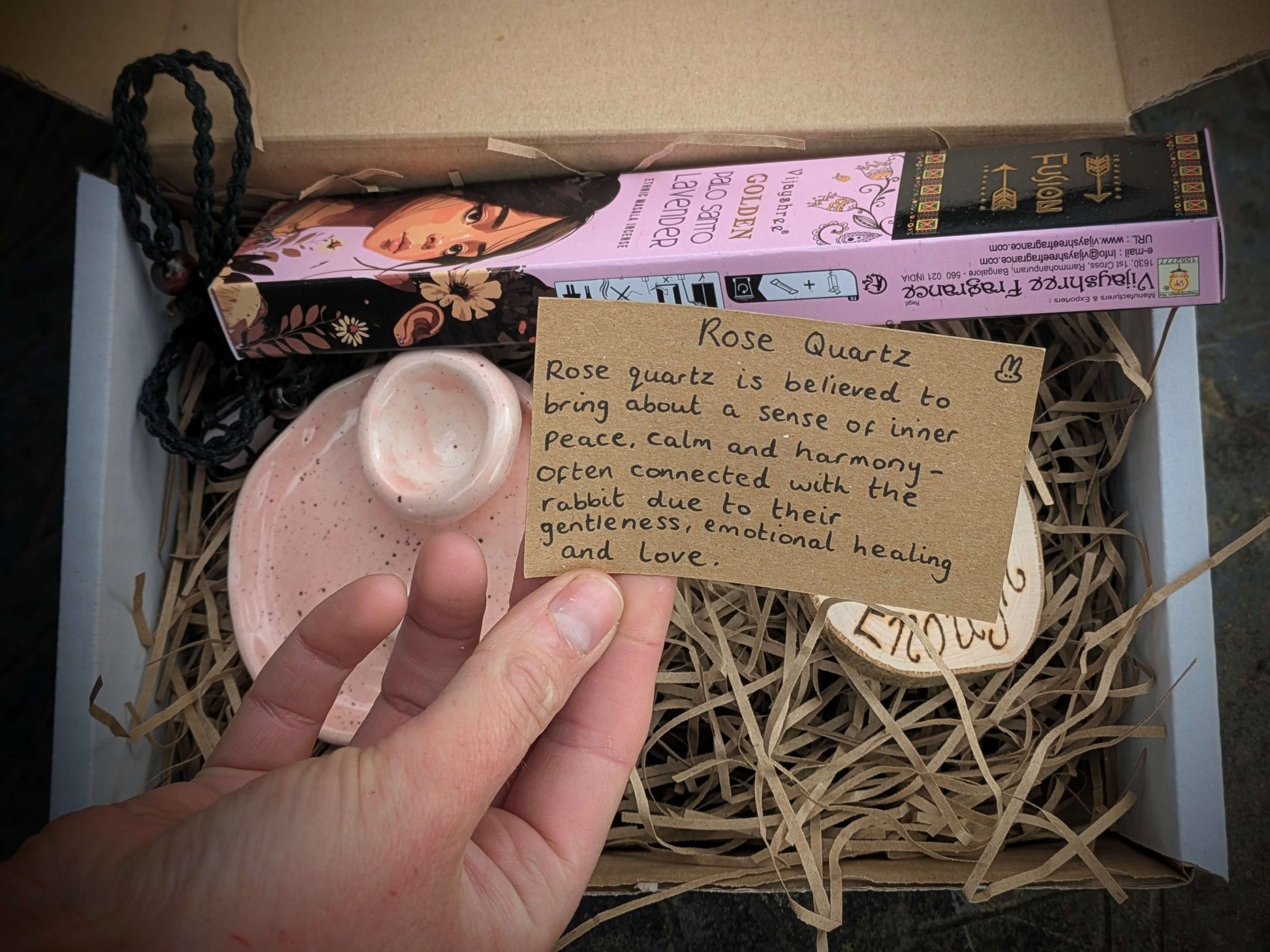 Close-up of ethically sourced crystal necklace with incense and engraved wooden disc