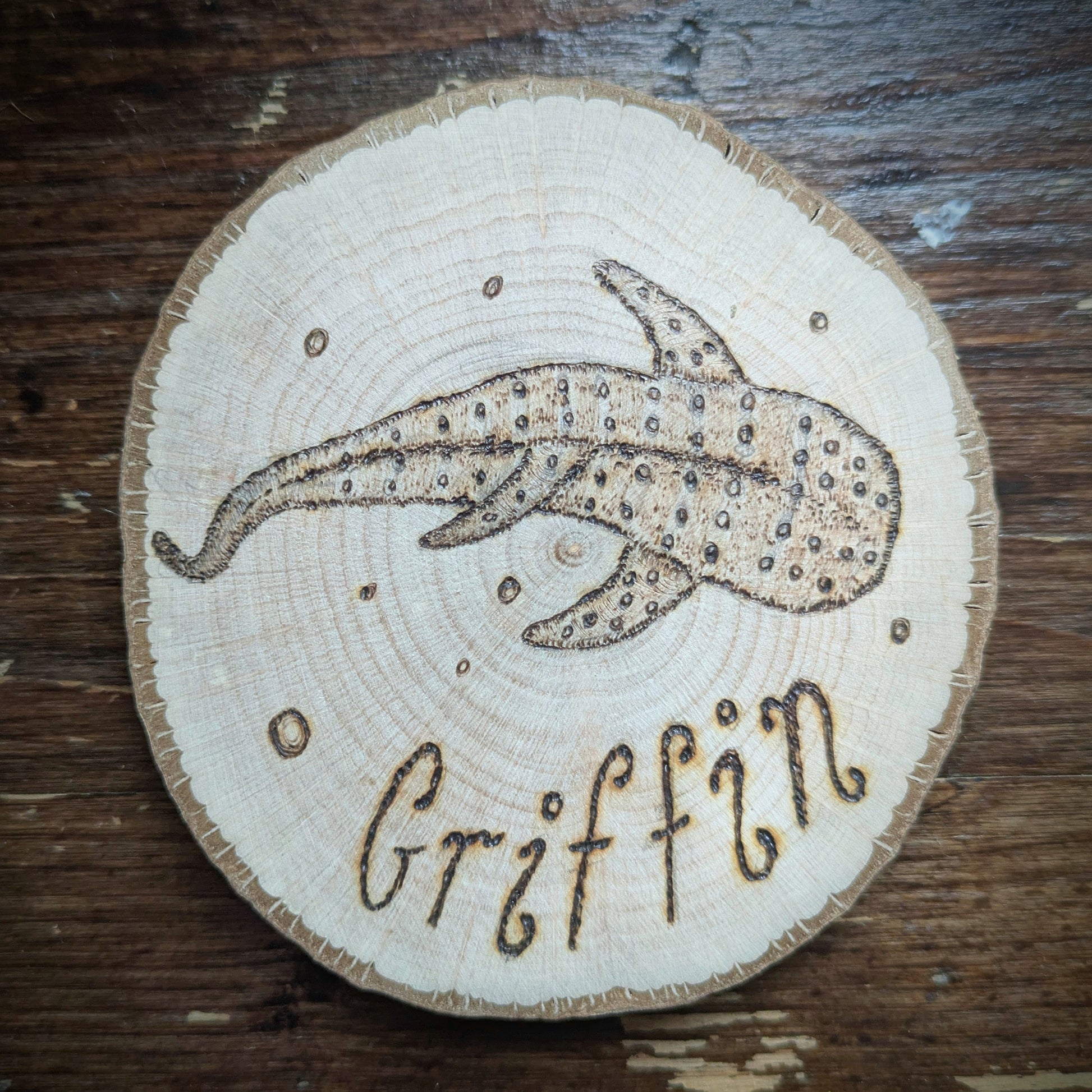 Wooden coaster with a whale shark design and 'Griffin' engraving on a wooden surface