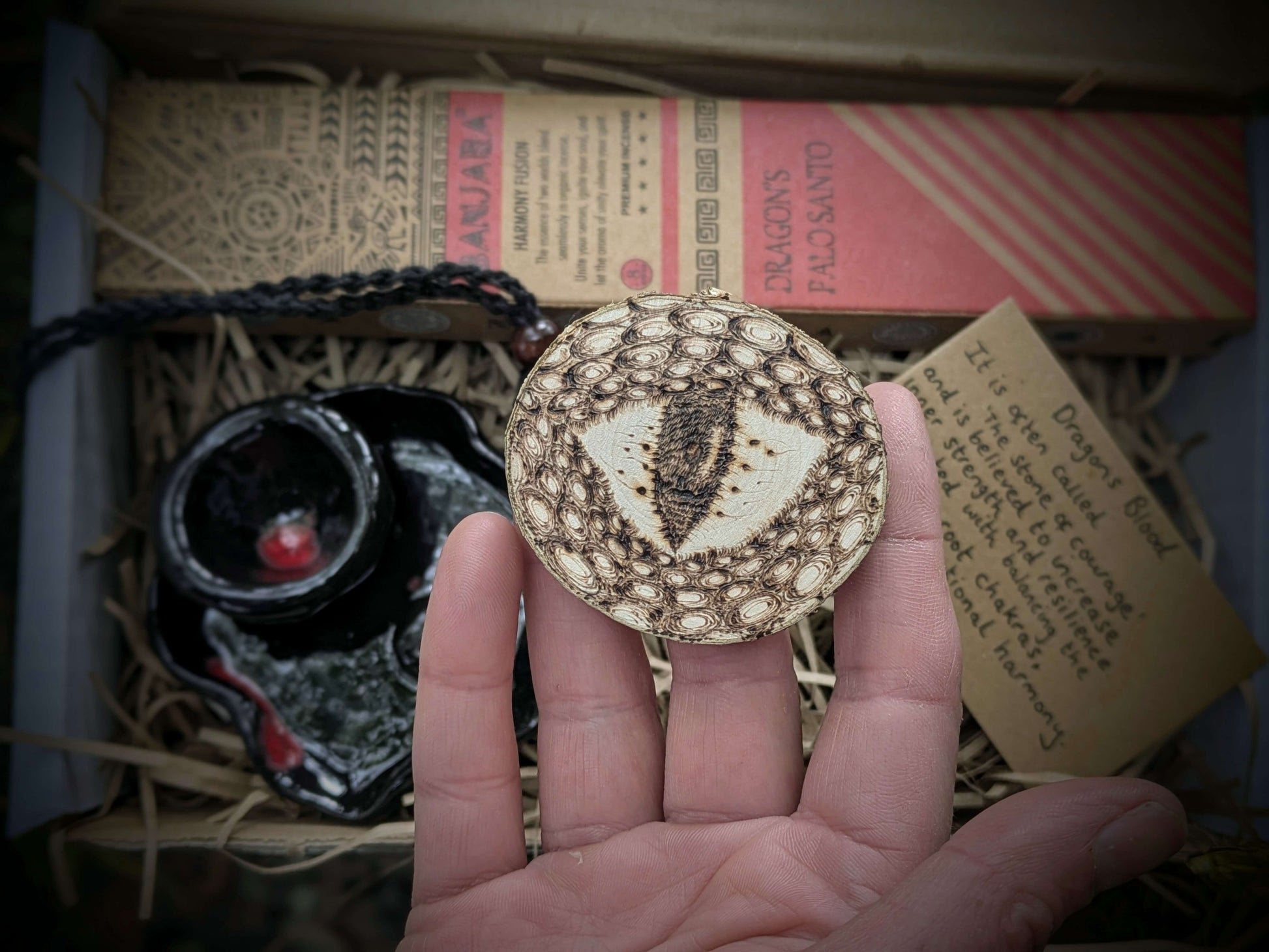A spiritual wellness item featuring Dragon’s Blood-themed grounding set with crystal-inspired imagery, incense, and ritual accessories in a warm, earthy aesthetic.